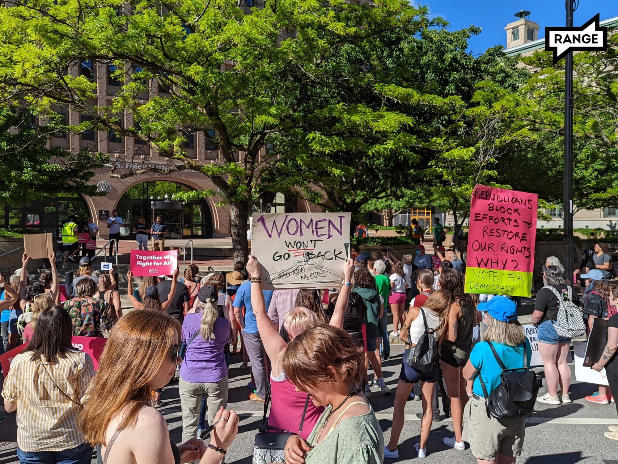 People supporting abortion rights protest in front of a Spokane courthouse with signs saying "Women won't go back" and other slogans to push back against abortion bans. 